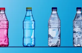 Four plastic water bottles in pink, blue and clear on blue background