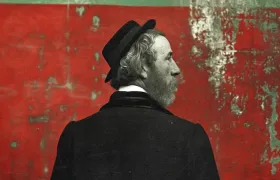 Illustration of a bearded 19th-century businessman in a bowler hat seen from behind against a weathered red wall, evoking P&G's founding era