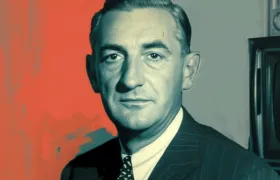 Mid-century businessman in pinstripe suit beside a vintage television set