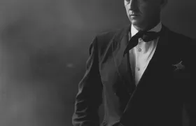 Christian Dior in a dark suit and bow tie, black-and-white portrait