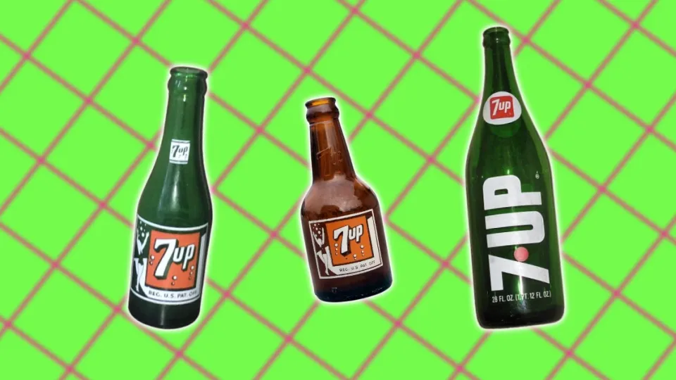 Three vintage 7 Up glass bottles with paper and painted labels
