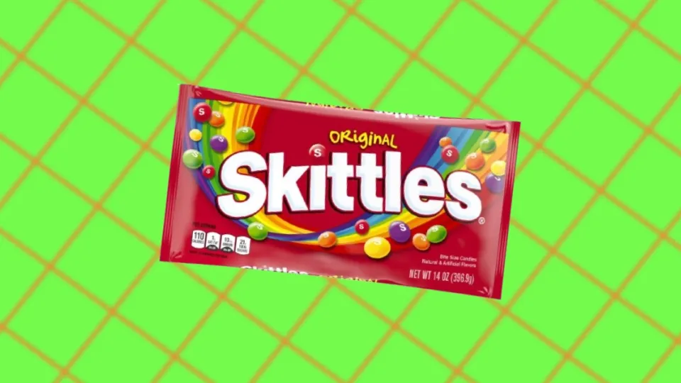 Original Skittles candy bag on a green grid background