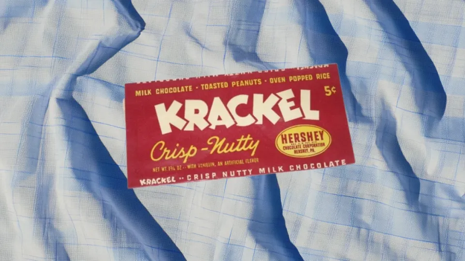 Vintage five-cent Krackel Crisp-Nutty chocolate bar wrapper on blue plaid fabric