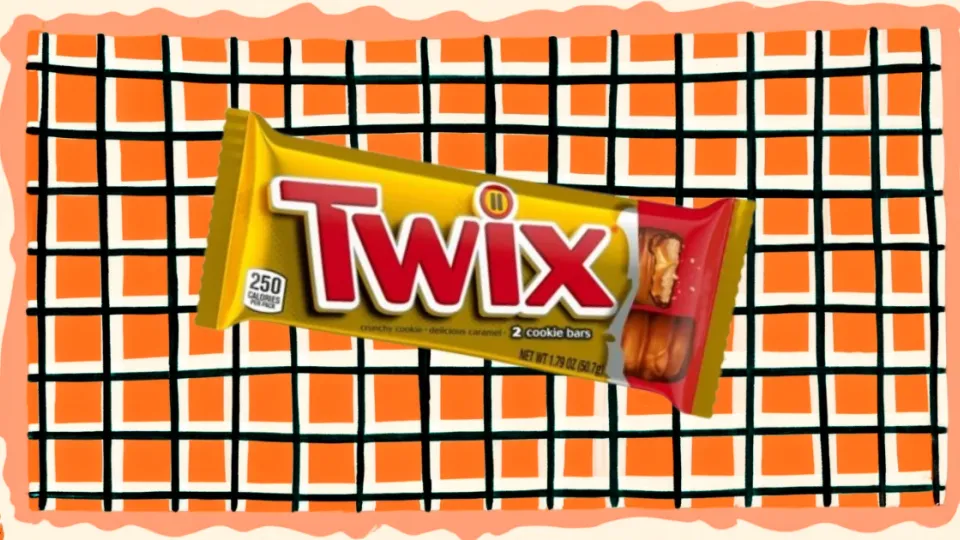 Twix candy bar in gold wrapper on orange checkered background