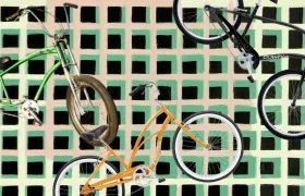 Three Electra cruiser bicycles on a painted green checkered background