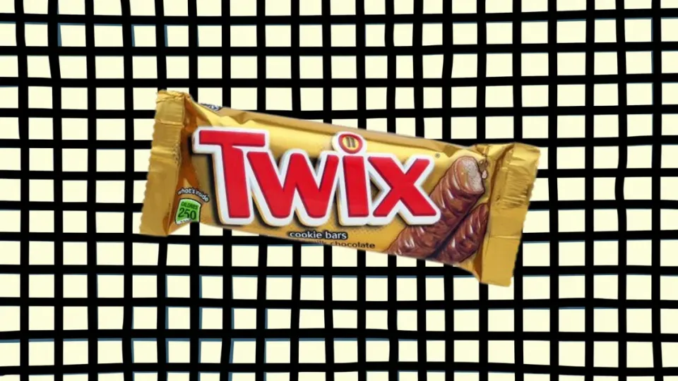 Twix candy bar in gold wrapper on checkered background
