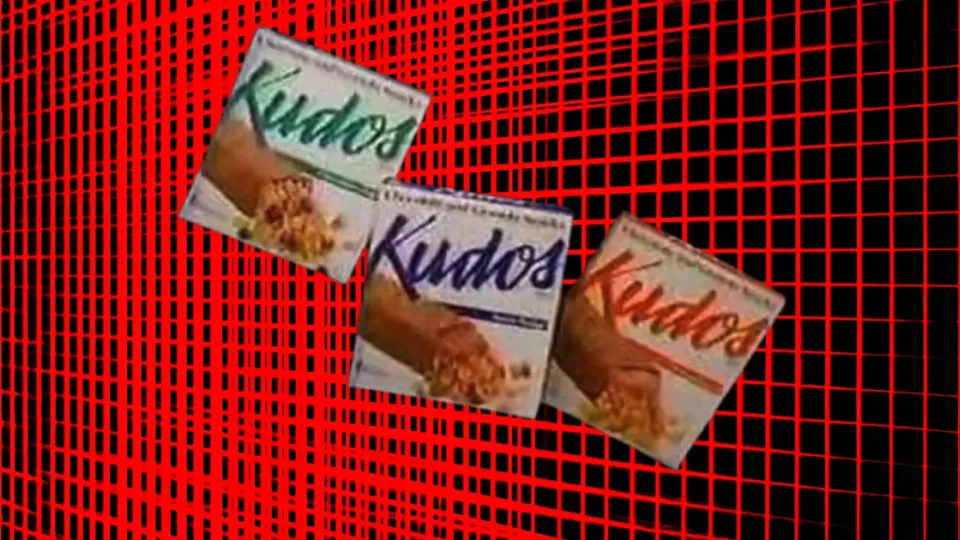 Three vintage Kudos granola bar boxes on a red grid background