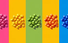 Piles of pink, yellow, green, orange and blue candies on color-blocked stripes