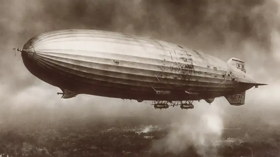 Sepia photograph of a rigid zeppelin airship flying above the clouds
